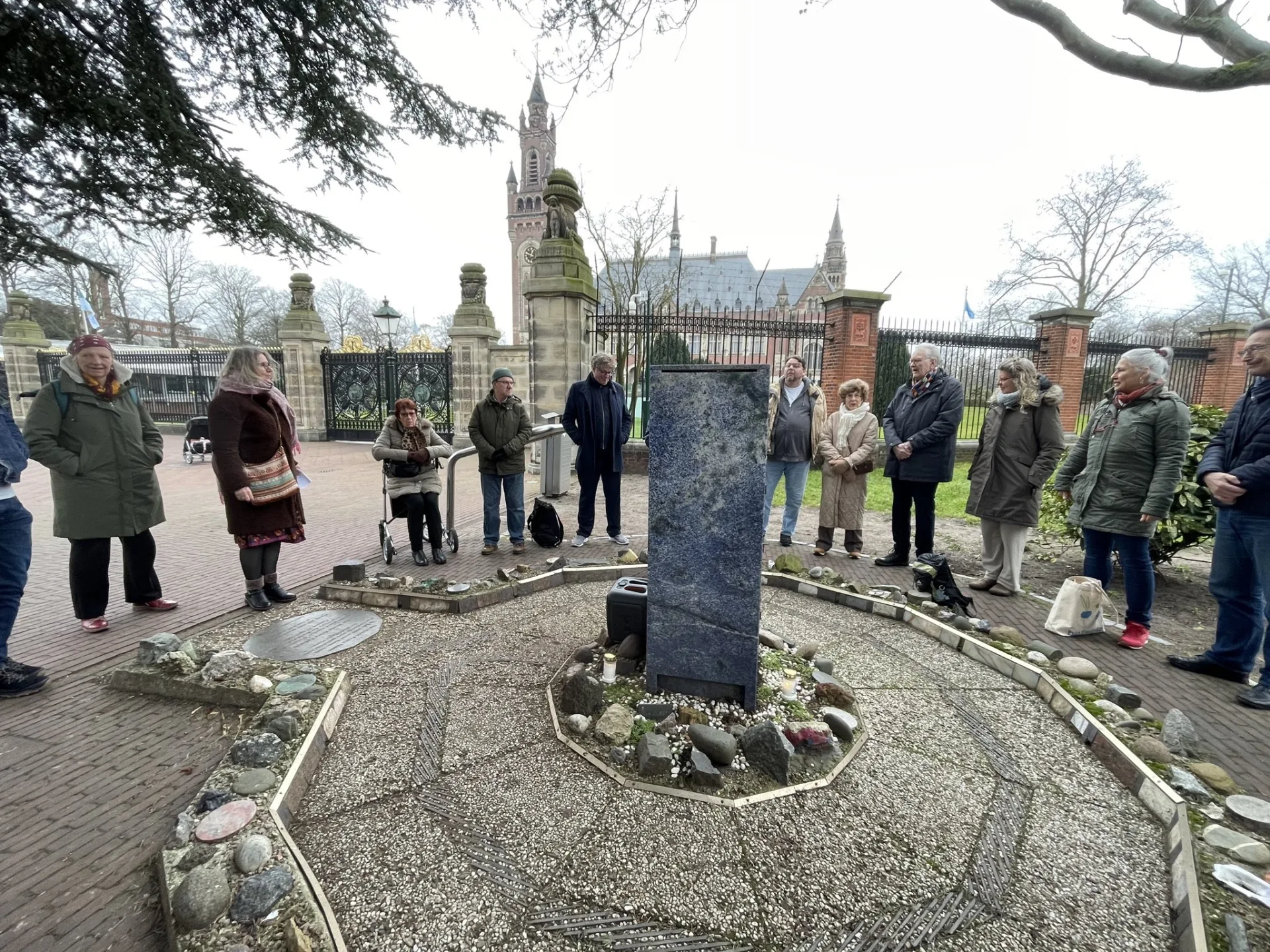 Deelnemers in een kring bij de Vredesvlam tijdens de vredeswake van februari 2026