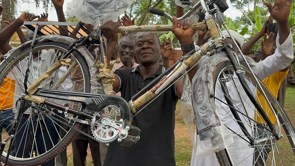 Een vader houdt blij zijn nieuwe fiets omhoog