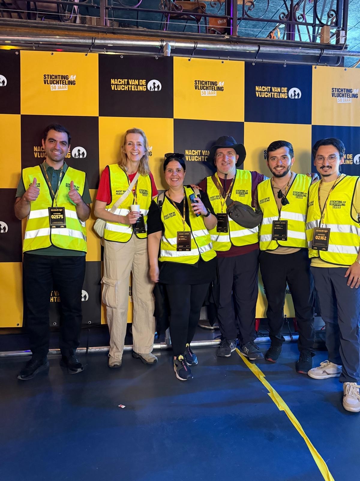 Het team van wandelaars in gele hesjes bij de start van de Nacht van de Vluchteling